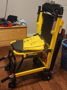 Yellow and black light weight metal chair with 4 wheels.