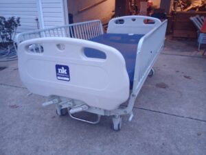 front view of hospital bed with rails on all sides and wheels