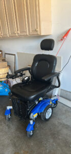 angled view of electric wheelchair, highlighting its blue base