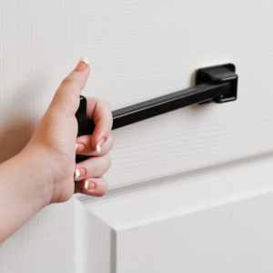 Black horizontal device attached to door with T shaped handle