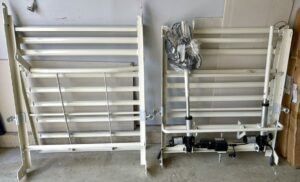 Appears to be the two bases for the hospital bed. Bases are white, and one base has the power pack attached to it.