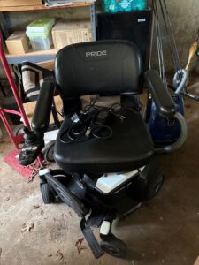 Front view of electric wheelchair. Power cord is lying on the chair.