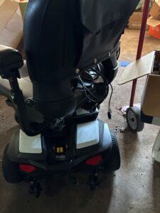 Back view of power wheelchair. A large storage pocket is visible on the back of the seat.