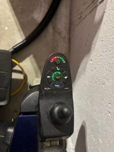 Close-up of wheelchair’s control panel with joystick.