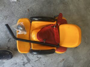 overhead view of pediatric seat with wheels, showing the handle bar detached