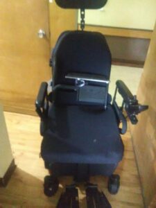 A front view of a power chair with a blue base.