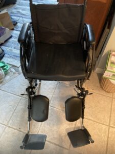 black manual wheelchair with arm rests and 2 leg/foot rests
