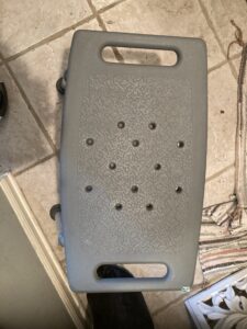 top view of gray rectangular seat with handles and small holes in the middle