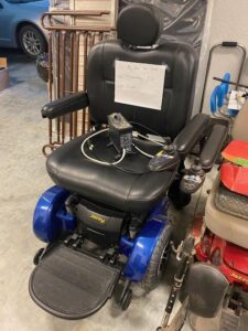front view of a power scooter seat with arm rests, a foot platform, and blue finish on the bottom of the scooter