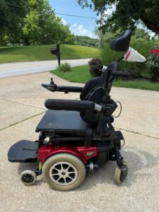 Side view of power chair. A sock is pulled over the left armrest.