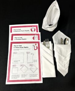 3 papers with step by step instructions for folding, and 3 white napkins in differently folded styles