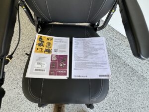 Close up of power chair seat. Product registration and product specification sheets are on the seat.