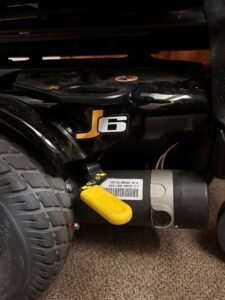 Close up of base of power wheelchair. Includes a J6 logo.