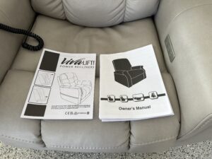 Close up of recliner seat. An informational booklet and an owner’s manual are on the seat.