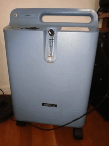 gray suitcase-like device on wheels with cord, on/off button, a number reader to 5, and text that says 