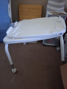 White base for shower chair, pictured separately from seat.