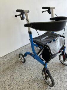 Rollator with blue base. The backrest and detachable bag are attached to the Rollator. Like new condition.